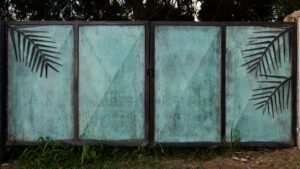 Two old, weathered metal frames with a greenish patina stand outdoors.