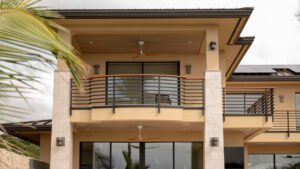 Modern balcony with metal railing and ceiling fan.