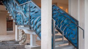 Blue abstract mural decorates stairwell walls in an indoor setting.