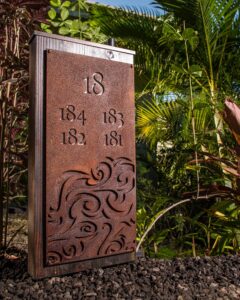 Golf course yardage marker with foliage background.
