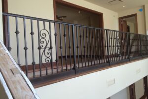 Ornate metal railing on indoor balcony.
