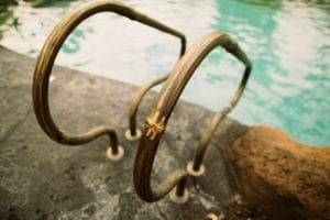 Rusty metal handrails by a swimming pool.