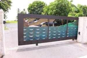 Modern metal gate with wave-patterned panels in a residential area.
