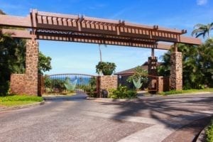 Entrance gate to a residential community with clear blue sky.