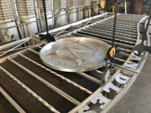 Metal pan with a cross-shaped divider on a grill.