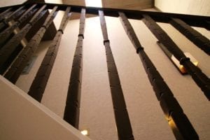 Close-up of a ceiling with exposed wooden beams casting shadows.