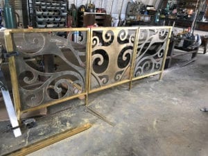 Decorative metal panels with swirling patterns in a workshop.