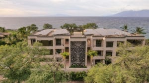 Modern building with a central decorative water feature overlooking the ocean.