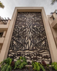 Intricate metal gate with tree design in building entrance.