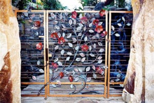 Decorative metal gate with artistic floral design and red accents.