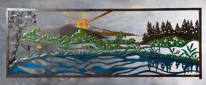 A stained glass artwork depicting a sun over a river and green landscape.
