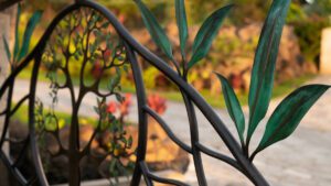 Close-up of a decorative wrought iron gate with leaf designs in autumn.