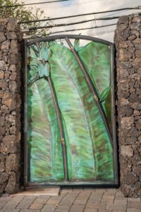 A decorative stained glass door with green banana leaf design.