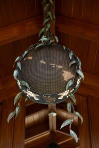 A decorative hanging globe with laurel leaves detail.