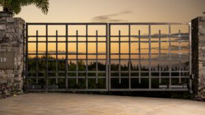 Metal gate with geometric design at sunset overlooking greenery.