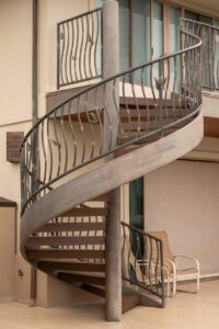 Rusty spiral metal staircase outside a building.