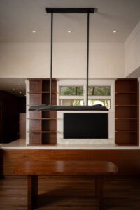 Modern living room with a sleek TV and wooden shelves.