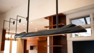 Modern black pendant light fixture hanging from ceiling in a stylish room.