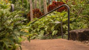A stairway with a rusty railing surrounded by lush greenery.