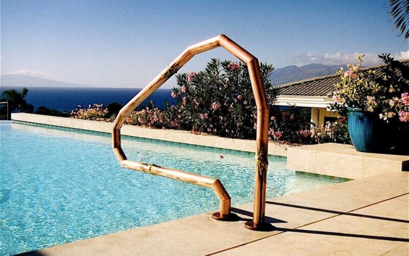 Unique poolside sculpture resembling an abstract figure near the water.