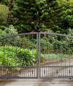 Elegant metal gate opening to a lush garden path.