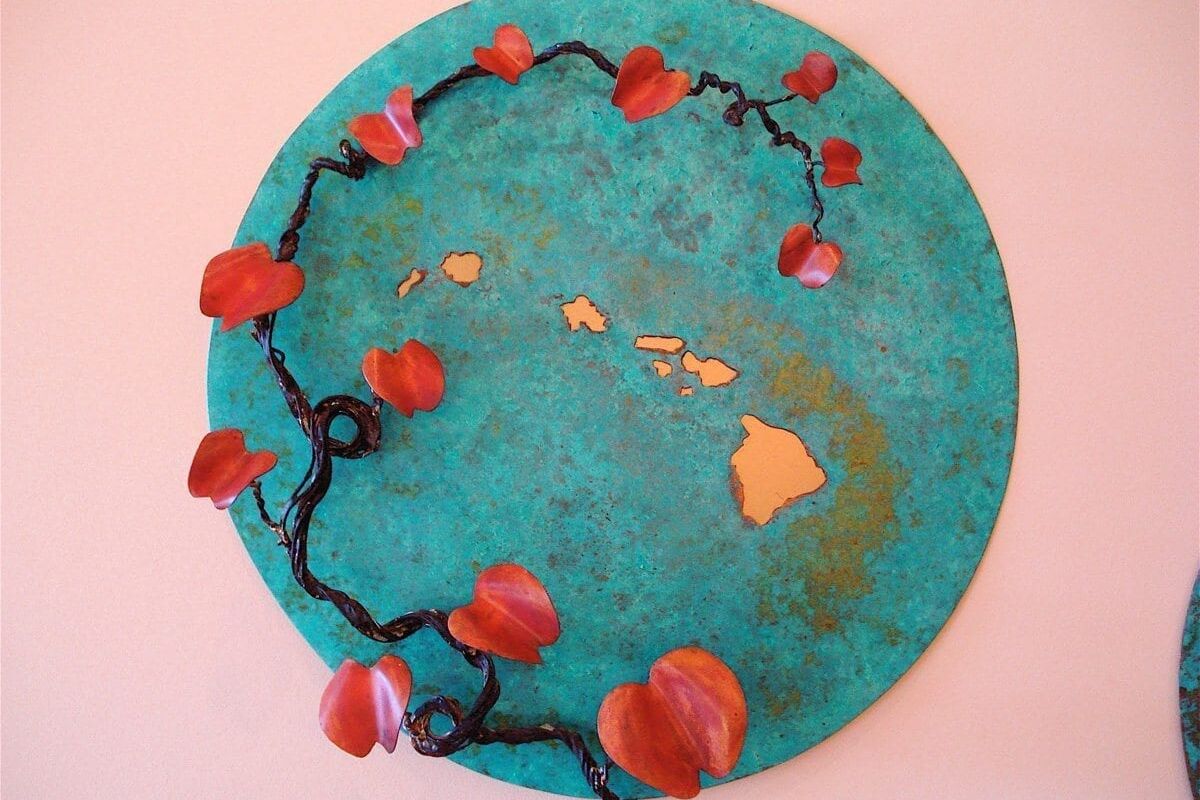 A circular artwork featuring a map of Hawaii with red flowers encircling it.