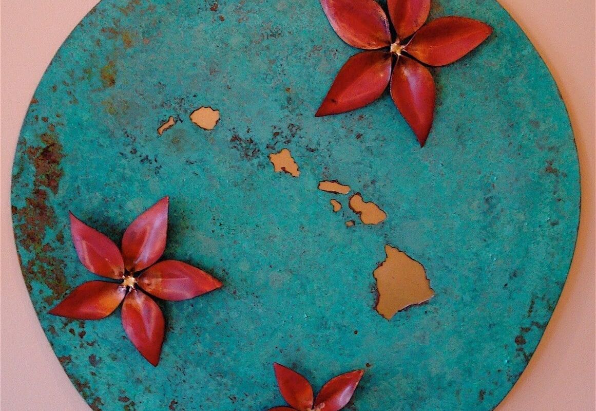 A round turquoise plaque with red flowers and gold accents.