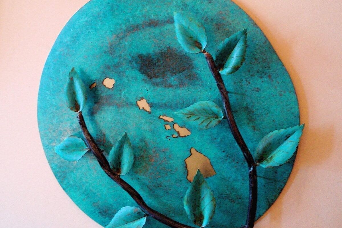 Green felt beret with embroidered floral design and leaves.