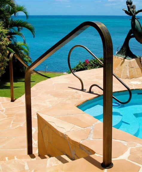 Elegant poolside with ocean view and bronze handrails.