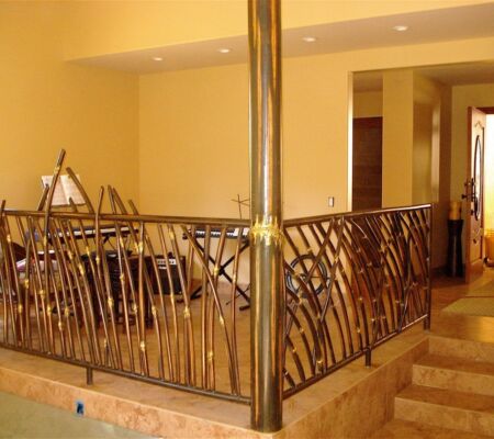 Elegant wrought iron railing with decorative design on indoor stairs.