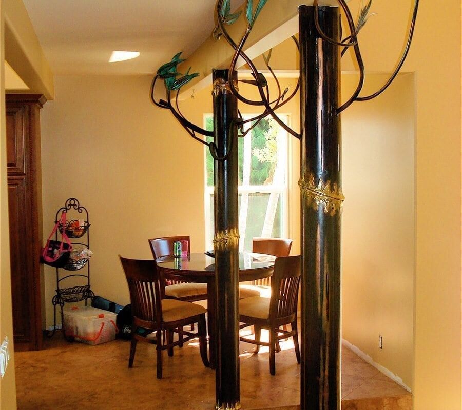 Dining area with wooden table and chairs under a window letting in natural light.