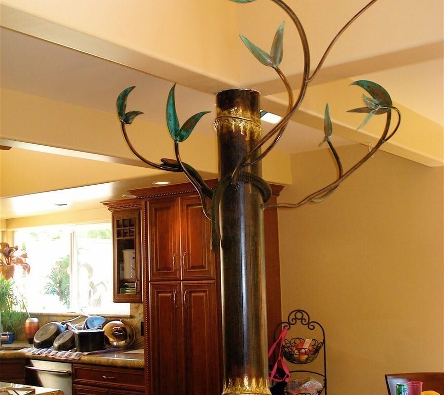 Decorative indoor stove pipe with artistic leaf design.