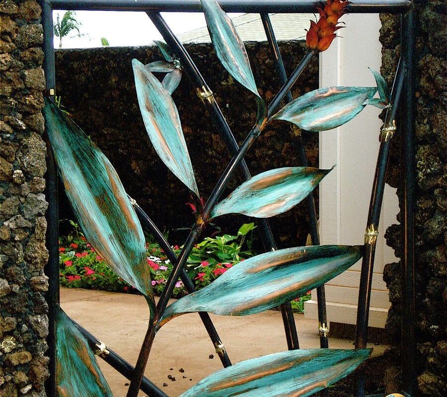 Decorative glass art featuring fish and leaves framed by stone.