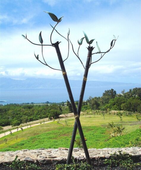 Three birds perched on a minimalistic metal sculpture against a scenic landscape.