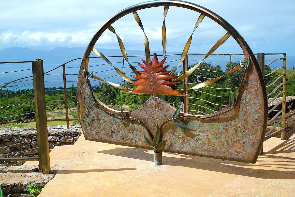Decorative metal gate with a sun design and spikes.
