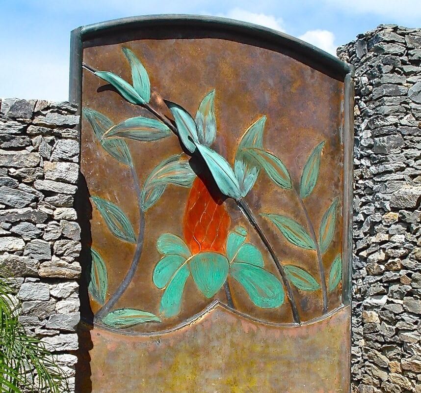 Rusty metal panel with a painted green bird and leaves.