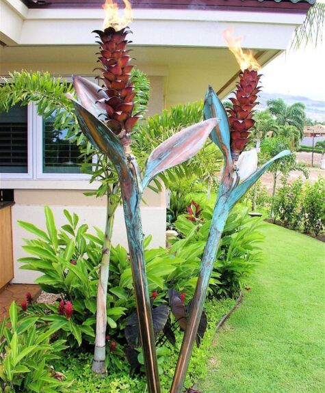 Decorative garden sculpture of large flowers near a house.