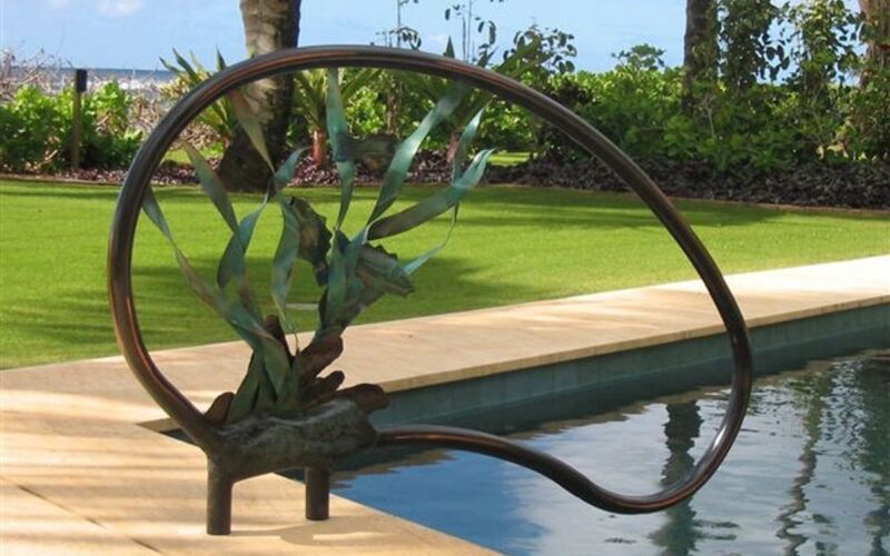Decorative metal plant sculpture near a pool and garden area.