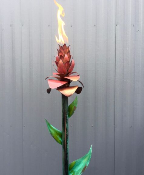 A unique flower with a flame burning on top against a gray background.