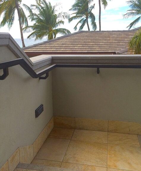 Small balcony with tiled floor and palm trees in background.