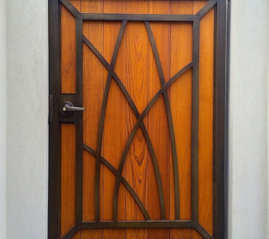 Wooden door with decorative geometric patterns and a black frame.