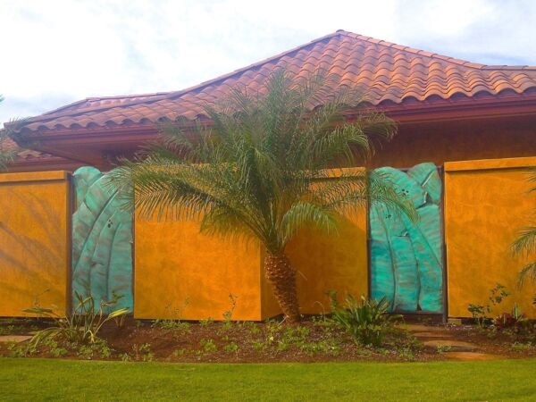 Colorful house with blue doors and a palm tree in front.