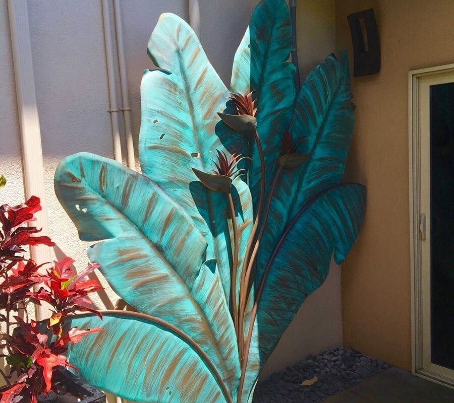 Decorative large leaf sculptures in a garden corner.