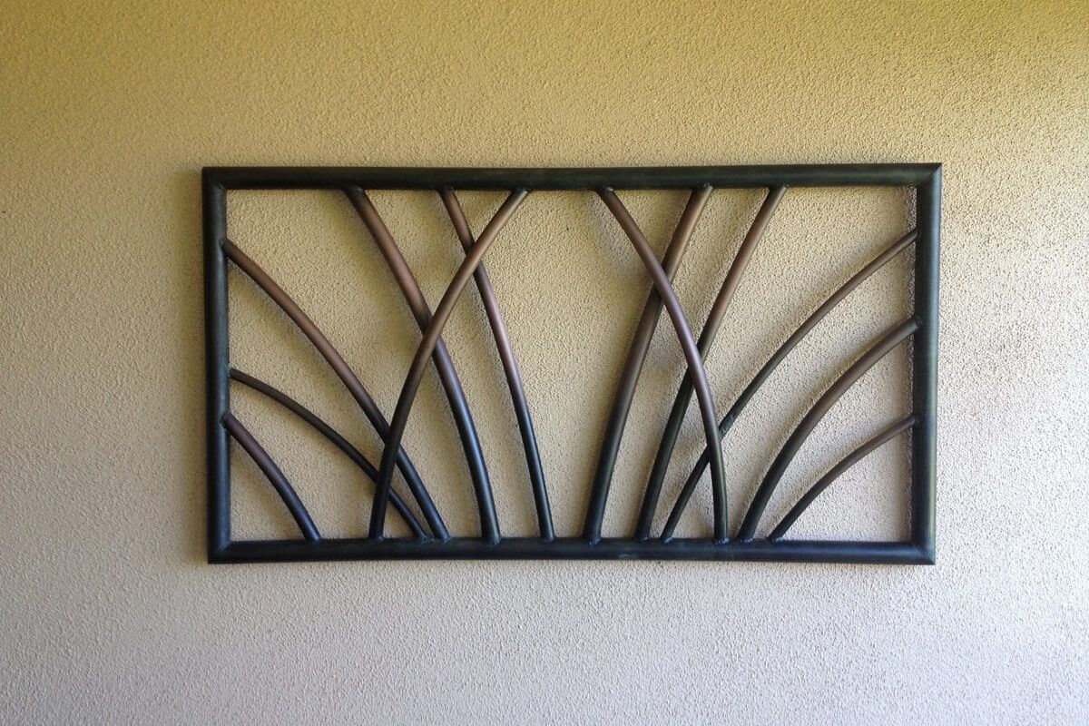 Decorative metal wall art with curved lines in a rectangular frame.