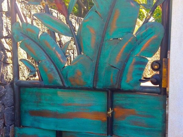 Rustic metal gate with turquoise banana leaf design.