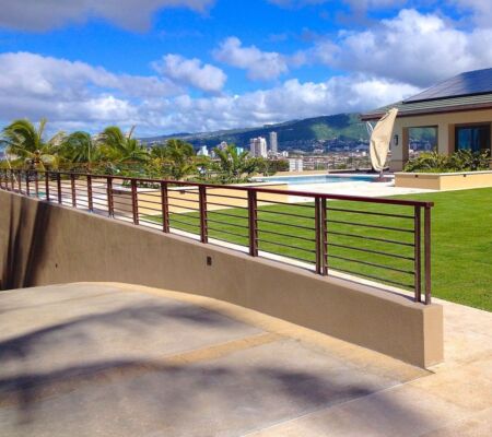 Sunny waterfront promenade with clear sky and distant cityscape.