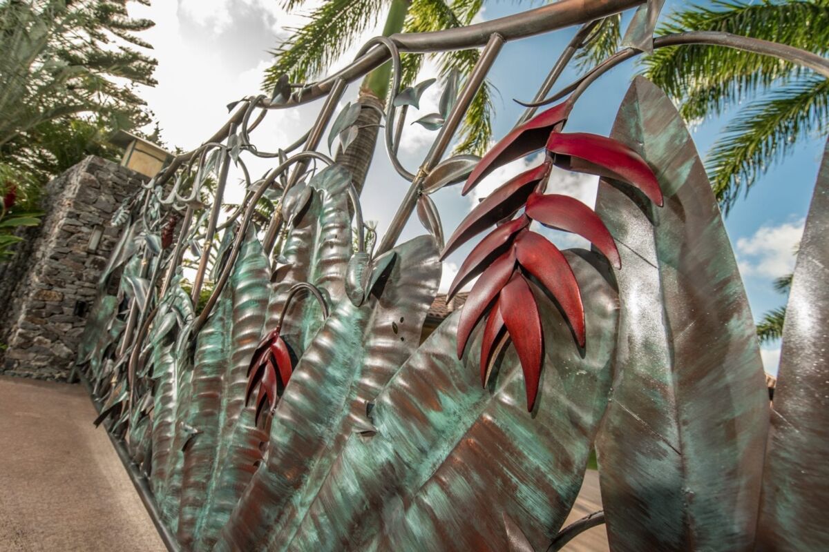 Decorative metallic leaves in an outdoor setting under palm trees.