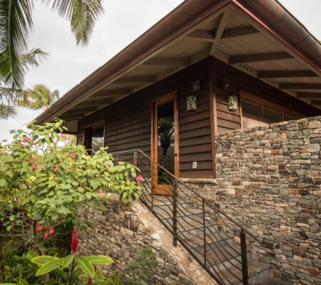 Palm-framed modern bungalow with stone walls