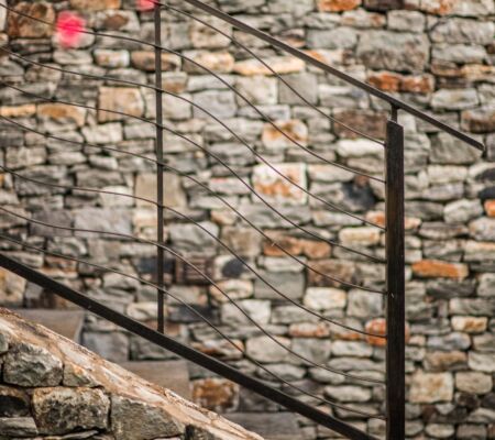 Stone wall with metal handrails and stairs.