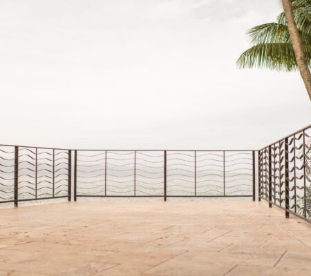 Empty balcony with metal railing overlooking a foggy view.